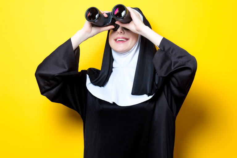 Giovane suora felice con binocolo